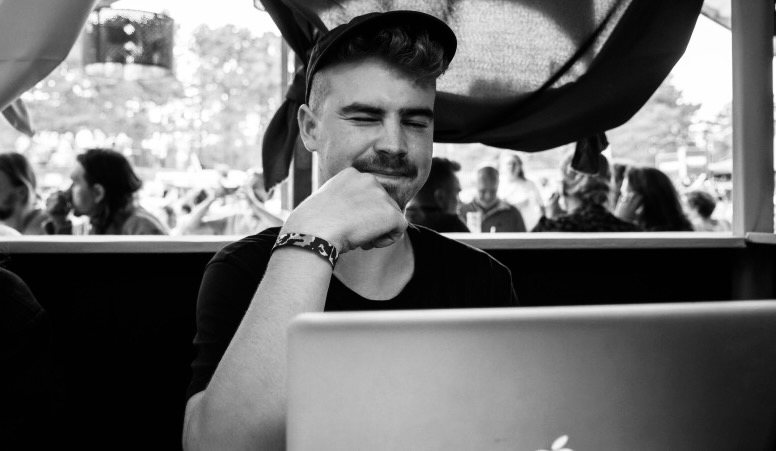 Jeppe Heyvaert achter zijn laptop op een festivalterrein